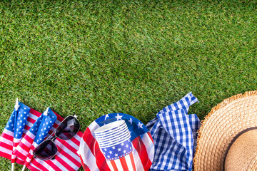 July 4, Independence Day traditional American picnic background. Plates, glasses, USA flags on green lawn or meadow grass, with blanket or tablecloth for picnic, sunglasses, copy space top view - 787167329