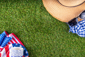 July 4, Independence Day traditional American picnic background. Plates, glasses, USA flags on green lawn or meadow grass, with blanket or tablecloth for picnic, sunglasses, copy space top view - 787167354
