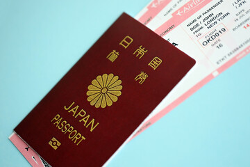 Japan passport with airline tickets on blue background close up. Tourism and travel concept