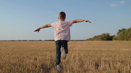 boy child running across field playing airplane flight dream, creative child play, escape game...