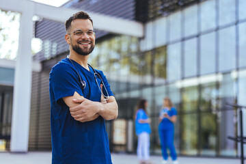 Medical professional working in a hospital. He is dressed in scrubs looking at the camera smiling with a stethoscope around his neck. Young male nurse home caregiver - 787171739