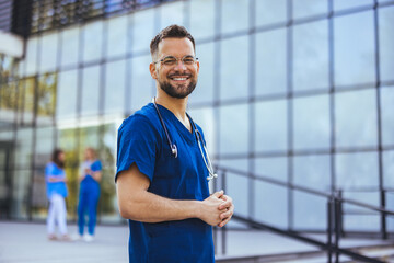 Medical professional working in a hospital. He is dressed in scrubs looking at the camera smiling with a stethoscope around his neck. Young male nurse home caregiver - 787172189
