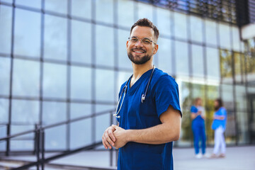 Medical professional working in a hospital. He is dressed in scrubs looking at the camera smiling...