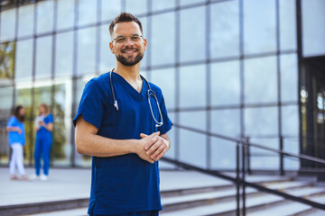 Medical professional working in a hospital. He is dressed in scrubs looking at the camera smiling...