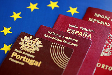 European union countries passports on blue EU flag close up. Portugal, Spanish, French and Italian passports