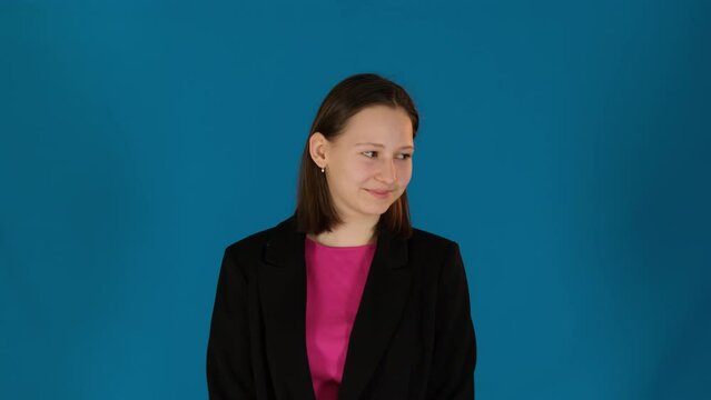 Smiling lady looks away feeling shyness on blue background. Woman with cheeks flushed with rosy hue casts gaze aside with bashful smile