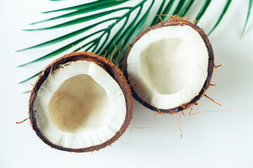Broken coconut and palm leaf on a white background. - 787177738