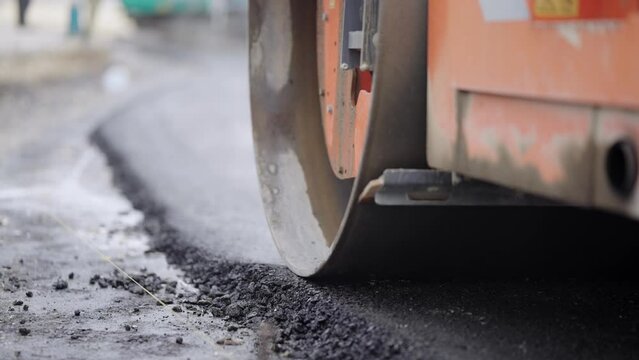 Steam compactor rollers working on the new road construction site laying new asphalt, slow motion