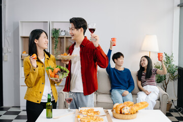 Group of Young Asian friend having, enjoy evening party together at home. Attractive young man and woman having fun, eating food, celebrate at home
