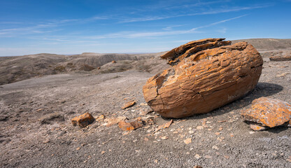 Large round red concretion on the horizon at Red Rock Coulee near Seven Persons, Alberta, Canada - obrazy, fototapety, plakaty