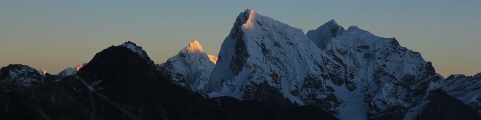 Sun lit mountain peaks of Ama Dablam and Cholatse at sunset, Nepal.