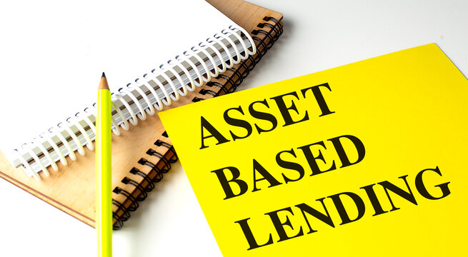 ASSET BASED LENDING text on yellow paper with notebooks