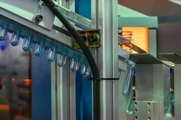 Conveyor belt deliver the preform shape to the  blow mold machine.