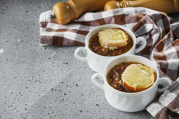 delicious original French onion soup on a light stone background