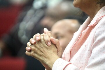Closeup shot of the hands of a praying woman