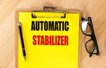 AUTOMATIC STABILIZER text on yellow paper on clipboard with pen and glasses