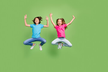 Full length photo of positive cheerful friends wear t-shirts jumping high rising hands arms...