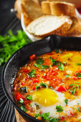 pan of delicious traditional israeli shakshuka on black wooden rustic background