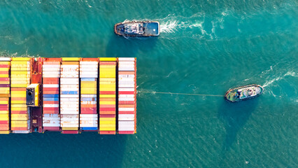 Top view Container ship full capacity approaching the port by a tugboat occupying the port International Container ship loading, unloading at sea port, Freight Transportation, Shipping,  Vessel.