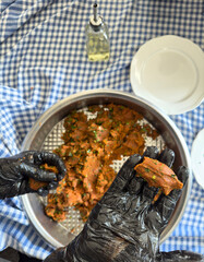 Steak tartar Turkish style, knead in metal bowl, man hand, using gloves, traditional culture, making raw meatballs.