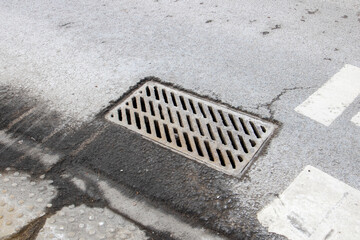 Grey rectangle manhole cover on asphalt road surface