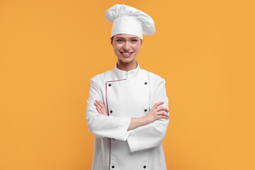 Happy chef in uniform on orange background