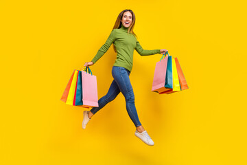 Full body photo of attractive sportive lady hold packages running good mood isolated on yellow color background