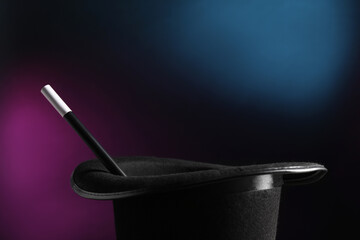 Magician's hat and wand on dark background, closeup
