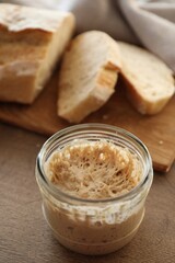 Sourdough starter in glass jar on wooden table