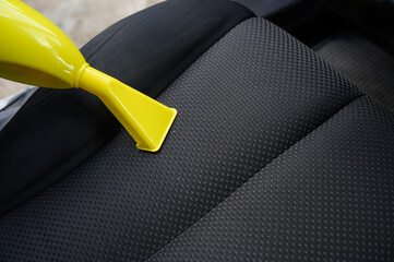 Cleaning car seat with vacuum cleaner, cleaning car seat seat from dirt, dust, close-up.Concept of...