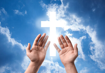 Religion. Christian man praying against sky with glowing cross, closeup