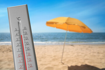 Thermometer on beach showing temperature, summer weather