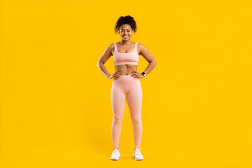 Black lady standing in fitness gear smiling