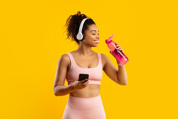 Athletic woman holding water bottle and phone