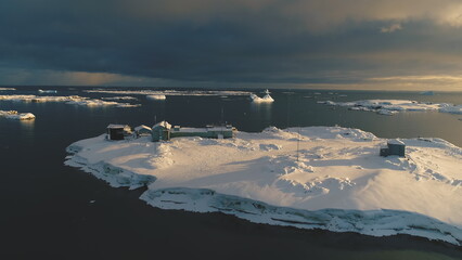 Slow-motion aerial drone view above Antarctic polar station - Vernadsky Base. Ocean coast open...