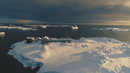 Slow-motion aerial drone view above Antarctic polar station - Vernadsky Base. Ocean coast open...