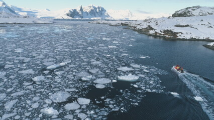 Zodiac Boat in Antarctica Ocean Aerial tracking. Drone Flight Overview of Antarctic South Pole. Rubber Boat Float in Frozen Winter Water Landscape Among Ice Shore. © mozgova