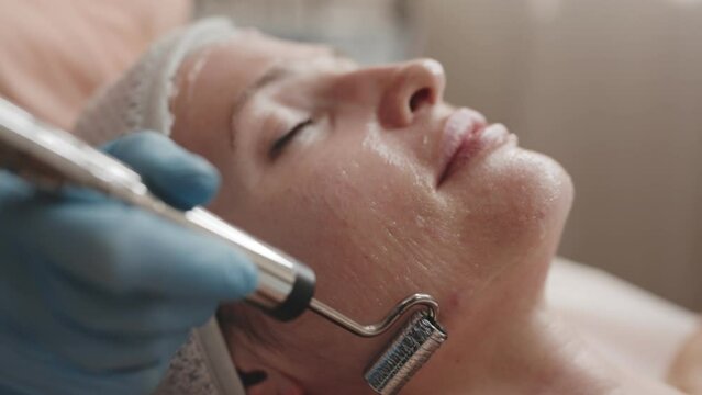 Close-up shot of a microcurrent therapy session for facial rejuvenation at a professional skincare clinic.