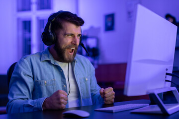 Gamer expressing happiness during a game at home - obrazy, fototapety, plakaty