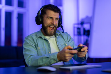 Gamer playing with controller and headphones at home