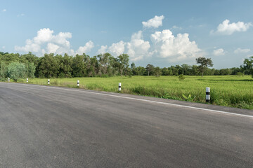 Side view of asphalt road with the meadow