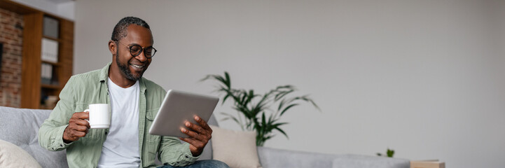 Smiling mature african american man watching video on tablet
