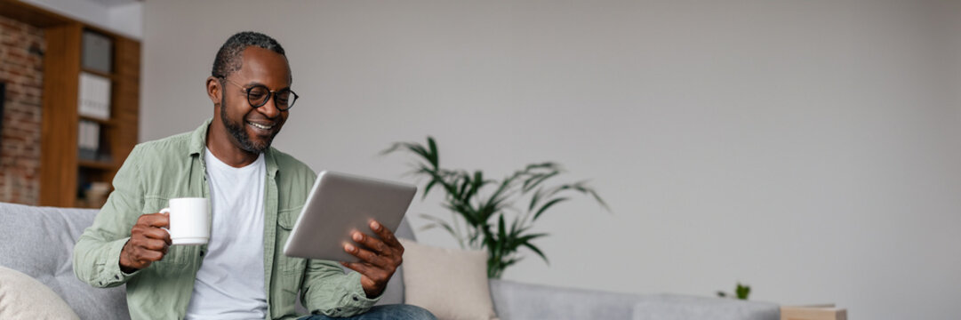 Smiling mature african american man watching video on tablet - Powered by Adobe