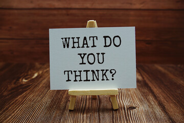 What do you think? text on paper card on wooden background