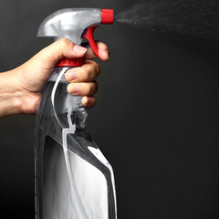 Hand, person or spray for cleaning studio on black background for domestic or housework chores....