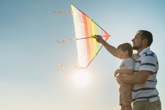 dad and little son 3 years old fly a kite in a field. Involved Parenting, International Father's Day