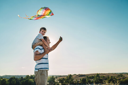 dad and little son 3 years old fly a kite in a field. Involved Parenting, International Father's Day