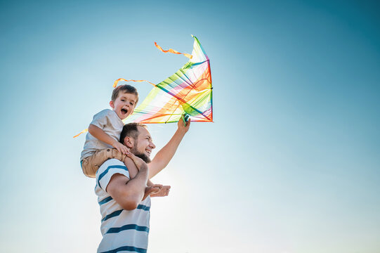 dad and little son 3 years old fly a kite in a field. Involved Parenting, International Father's Day