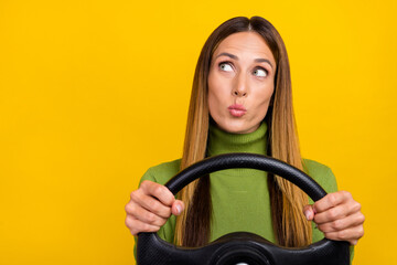 Portrait of minded lady pouted lips hold wheel look empty space isolated on yellow color background