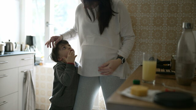 Tender Moment Between Mother and Son - Young Boy Leaning on Mom wanting a hug and embrace, Captured in an genuine, Authentic Family kitchen Setting